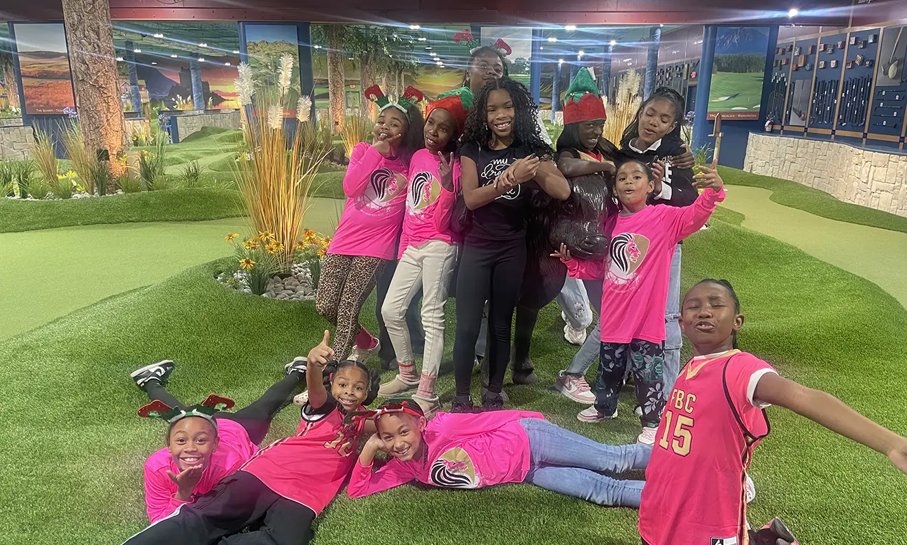 Group of girls from a charity smiling together on the green