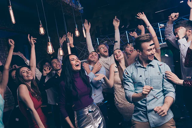 People dance at an event with confetti in the air